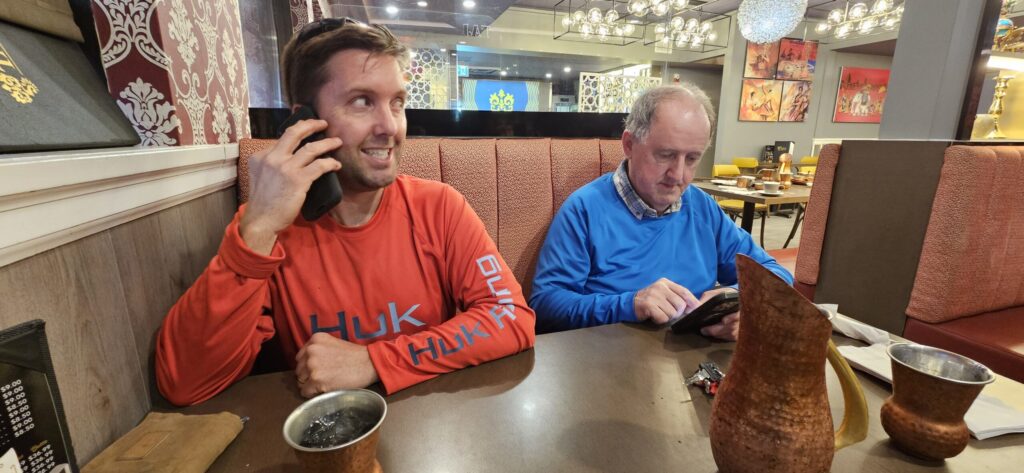 Two men sitting at a table in an Indian food restaurant