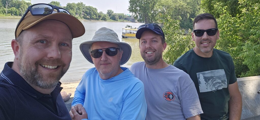 Four guys standing by the forks of the Assiniboine and Red Rivers