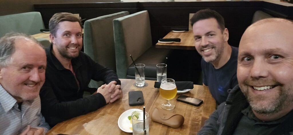 Four guys sitting at a table at a steakhouse