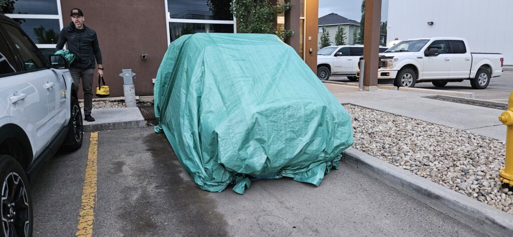 A Mini Moke covered in a green tarp