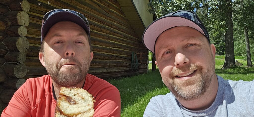 Two men eating a cinnamon bun